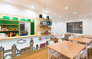 ロンドンの店内。テーブル席とロンドンの街並みを描いた壁